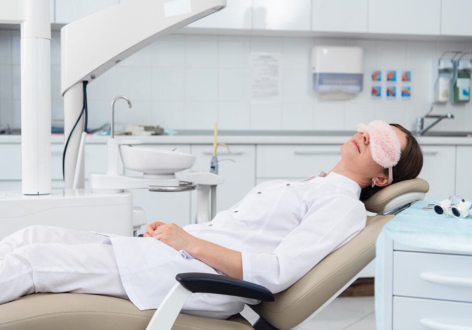 Patient relaxing at dental clinic with eye mask.