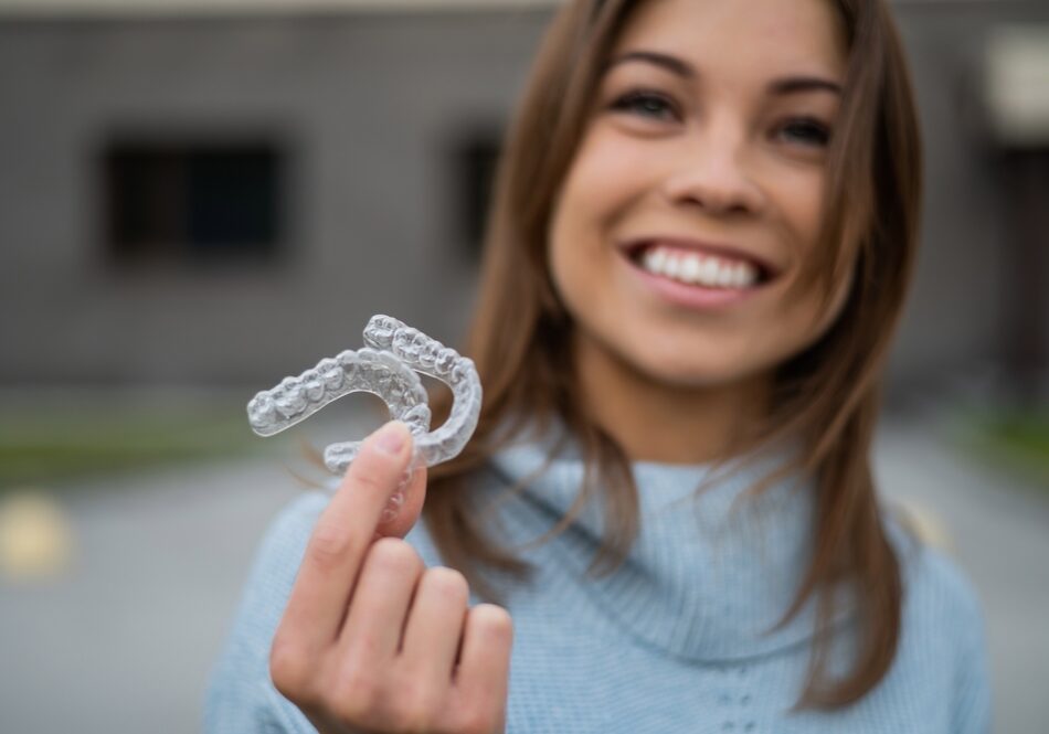 Caucasian,Woman,With,White,Smile,Holding,Transparent,Removable,Retainer.,Bite