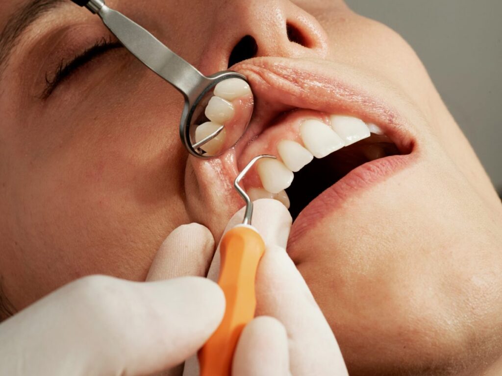 woman under sedation while dentist is working on her teeth