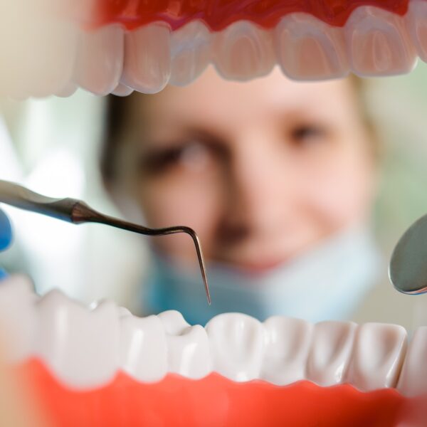 Dentist examining teeth with dental tool.