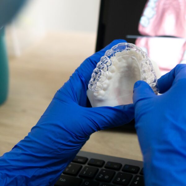 Dentist holding clear dental aligner model.